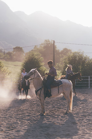 Young adults horse riding in rural equestrian arena, Primaluna, Trentino-Alto Adige, Italy Stock Photo - Premium Royalty-Free, Code: 649-09212965