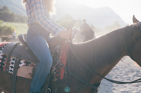 Young woman riding horse in sunlit equestrian arena, cropped, Primaluna, Trentino-Alto Adige, Italy Stock Photo - Premium Royalty-Free, Code: 649-09212961