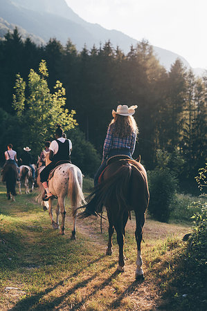 Young adult friends horse riding by forest, rear view, Primaluna, Trentino-Alto Adige, Italy Stock Photo - Premium Royalty-Free, Code: 649-09212997