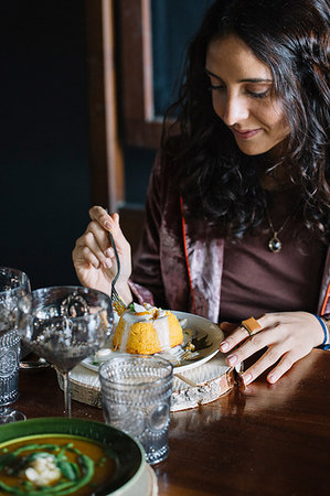 sponge puddings - Young woman eating dessert at restaurant table Stock Photo - Premium Royalty-Free, Code: 649-09213082