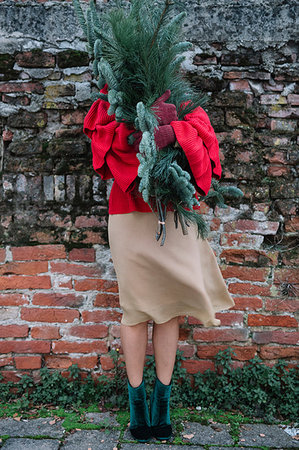 simsearch:649-09035869,k - Young woman in front of old brick wall holding christmas tree Photographie de stock - Premium Libres de Droits, Code: 649-09213116