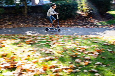 simsearch:614-09168173,k - Boy riding push scooter in park Photographie de stock - Premium Libres de Droits, Code: 649-09213503