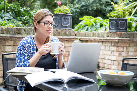 Pregnant mid adult woman looking at laptop on patio table Stock Photo - Premium Royalty-Free, Code: 649-09213672