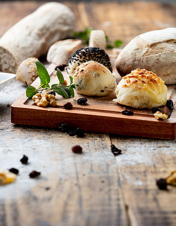 simsearch:649-06623037,k - Seeded bread rolls and rustic loaves on chopping board, still life Stock Photo - Premium Royalty-Free, Code: 649-09213705