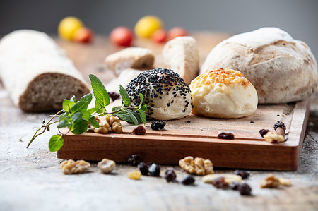 simsearch:649-06623037,k - Seeded bread rolls and rustic loaves on chopping board, still life Stock Photo - Premium Royalty-Free, Code: 649-09213707