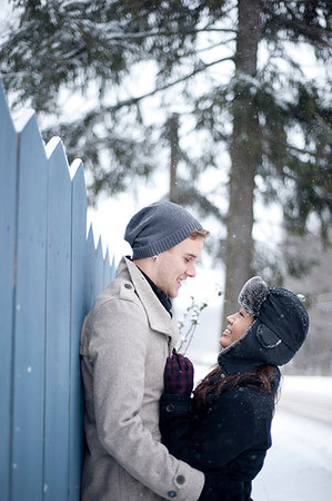 Young couple hugging against fence in snow Stock Photo - Premium Royalty-Free, Code: 649-09213700