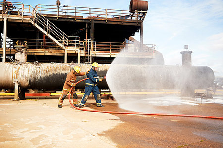 simsearch:649-09230169,k - Firemen training, firemen spraying water from fire hose at training facility Stock Photo - Premium Royalty-Free, Code: 649-09230196