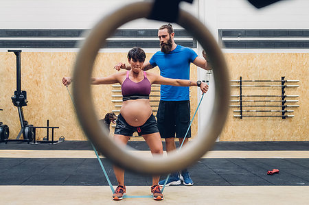 physically fit women wearing shorts - Trainer guiding pregnant woman using ropes in gym Stock Photo - Premium Royalty-Free, Code: 649-09230588