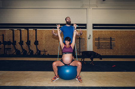 pregnant crop tops - Trainer guiding pregnant woman using ropes in gym Stock Photo - Premium Royalty-Free, Code: 649-09230593
