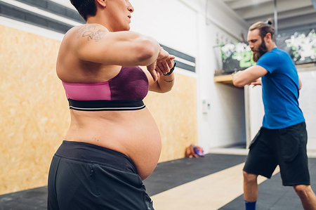 Pregnant woman and trainer warming up in gym Foto de stock - Sin royalties Premium, Código: 649-09230600
