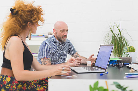 simsearch:649-09230621,k - Businessman and woman looking at laptop in office Foto de stock - Royalty Free Premium, Número: 649-09230644