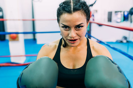 portrait of woman wearing boxing gloves - Portrait of female boxer in boxing ring Stock Photo - Premium Royalty-Free, Code: 649-09230708