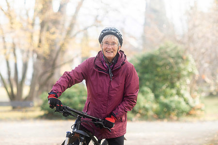 senior woman portrait biking outdoors alone - Senior woman on bicycle in park Stock Photo - Premium Royalty-Free, Code: 649-09230840