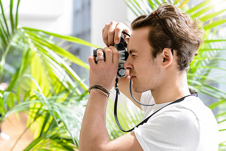 simsearch:614-06895809,k - Man taking photo, palm plant in background Stock Photo - Premium Royalty-Free, Code: 649-09230931