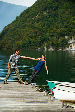 Mature couple balancing each other on edge of Lake Annecy pier, Annecy, Rhone-Alpes, France Photographie de stock - Premium Libres de Droits, Code: 649-09245907