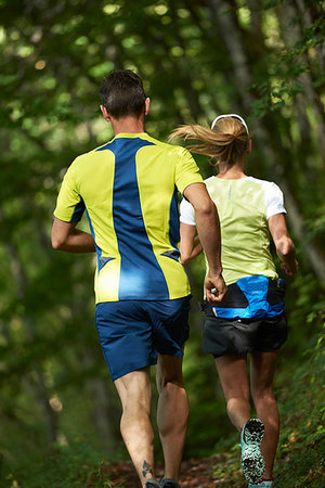 simsearch:614-07911952,k - Joggers running in forest Fotografie stock - Premium Royalty-Free, Codice: 649-09245937