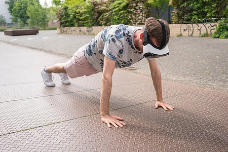 Man in push up position using virtual reality goggles, Berlin, Germany Foto de stock - Sin royalties Premium, Código: 649-09246026