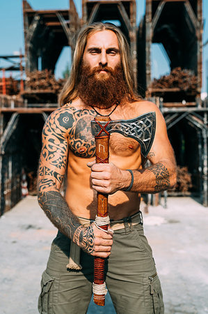 simsearch:649-09246447,k - Tattooed man showing off handcrafted axe Foto de stock - Sin royalties Premium, Código: 649-09246448