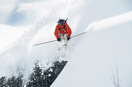 Male skier skiing mid air down snow covered mountain, Alpe-d'Huez, Rhone-Alpes, France Photographie de stock - Premium Libres de Droits, Code: 649-09246603