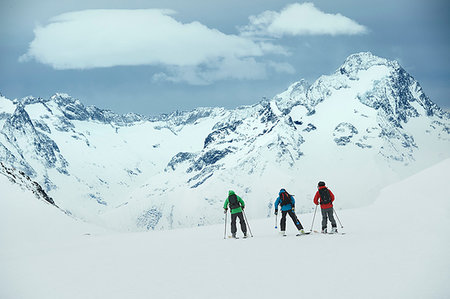 Landscape with three male skiers skiing toward mountain, rear view, Alpe-d'Huez, Rhone-Alpes, France Photographie de stock - Premium Libres de Droits, Code: 649-09246662