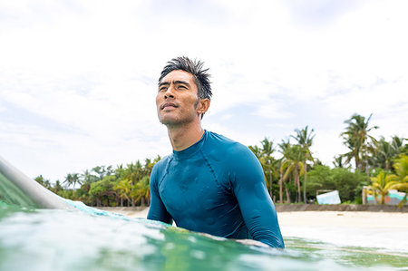 single coconut tree picture - Surfer waiting in sea, Pagudpud, Ilocos Norte, Philippines Stock Photo - Premium Royalty-Free, Code: 649-09246757