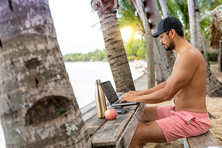 single coconut tree picture - Man on video call on laptop, Pagudpud, Ilocos Norte, Philippines Stock Photo - Premium Royalty-Free, Code: 649-09246752