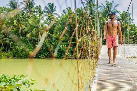 single coconut tree picture - Man on rope bridge, Pagudpud, Ilocos Norte, Philippines Stock Photo - Premium Royalty-Free, Code: 649-09246767