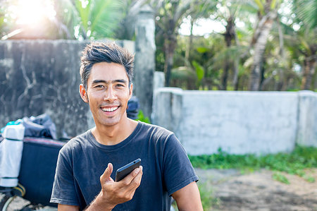 Man using cellphone on road trip, Pagudpud, Ilocos Norte, Philippines Stock Photo - Premium Royalty-Free, Code: 649-09246791