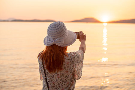 simsearch:649-09276061,k - Tourist taking photograph of sunset on beach Photographie de stock - Premium Libres de Droits, Code: 649-09246862