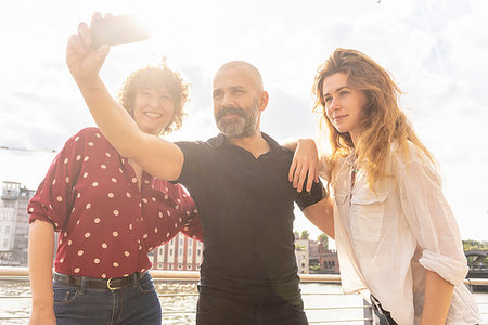 simsearch:649-07736373,k - Man and female friends taking selfie with smartphone on bridge Stock Photo - Premium Royalty-Free, Code: 649-09249878