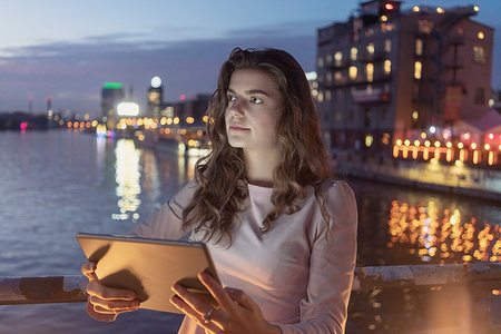 simsearch:614-08876867,k - Young woman using digital tablet on bridge, river and city in background, Berlin, Germany Fotografie stock - Premium Royalty-Free, Codice: 649-09249942