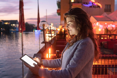 simsearch:649-09269390,k - Young woman using digital tablet on bridge, river and city in background, Berlin, Germany Stock Photo - Premium Royalty-Free, Code: 649-09249943