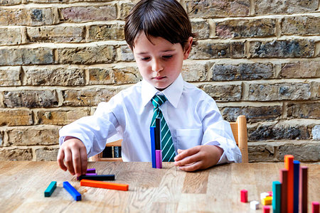 simsearch:649-09269303,k - Boy in school uniform playing with colour sticks at home Stock Photo - Premium Royalty-Free, Code: 649-09257285