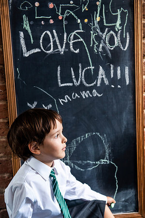Boy in school uniform beside blackboard at home Stock Photo - Premium Royalty-Free, Code: 649-09257288