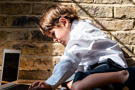 simsearch:614-06116419,k - Boy in school uniform using laptop at home Photographie de stock - Premium Libres de Droits, Code: 649-09257282
