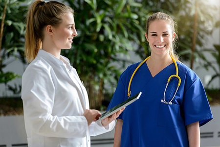 simsearch:649-09257295,k - Two female junior doctors using digital tablet outside hospital, portrait Fotografie stock - Premium Royalty-Free, Codice: 649-09257295