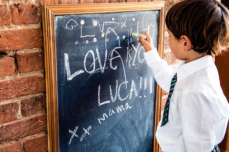 simsearch:614-06116419,k - Boy in school uniform writing on blackboard at home Photographie de stock - Premium Libres de Droits, Code: 649-09257290
