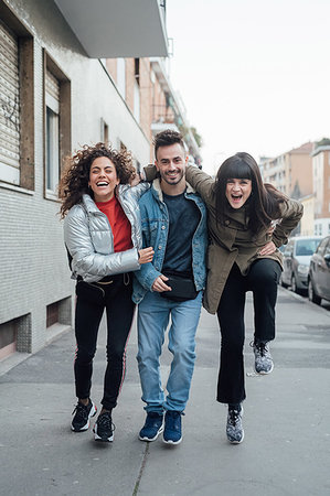 simsearch:649-08745093,k - Friends laughing and playing on pavement, Milano, Lombardia, Italy Foto de stock - Royalty Free Premium, Número: 649-09257503