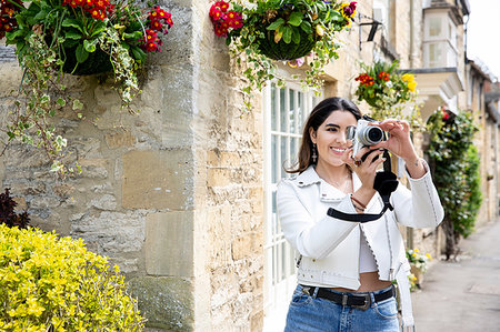 simsearch:649-08328031,k - Young woman on village street photographing with digital camera, Cotswolds, England Fotografie stock - Premium Royalty-Free, Codice: 649-09257721