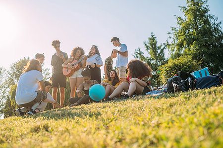 simsearch:649-08232578,k - Group of friends relaxing, playing guitar at picnic in park Stock Photo - Premium Royalty-Free, Code: 649-09257736