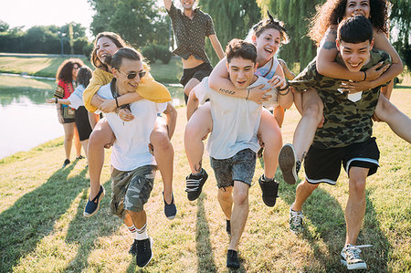 simsearch:649-08565670,k - Group of friends piggyback racing in park Stock Photo - Premium Royalty-Free, Code: 649-09257738