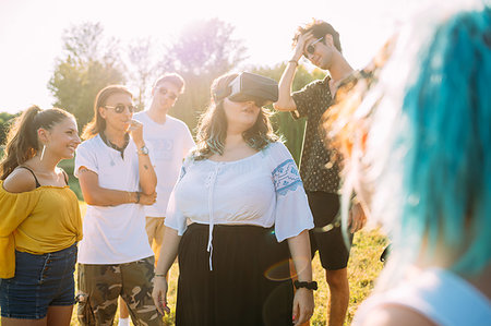 simsearch:649-09257797,k - Group of friends watching woman looking into VR headset in park Photographie de stock - Premium Libres de Droits, Code: 649-09257752