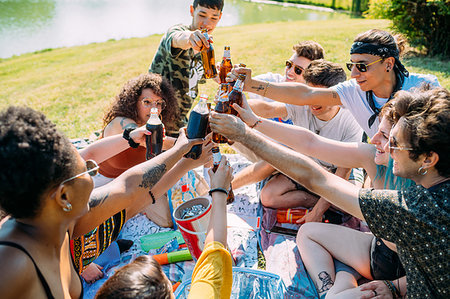 simsearch:614-08329177,k - Group of friends relaxing, toasting soft drinks at picnic in park Stock Photo - Premium Royalty-Free, Code: 649-09257838