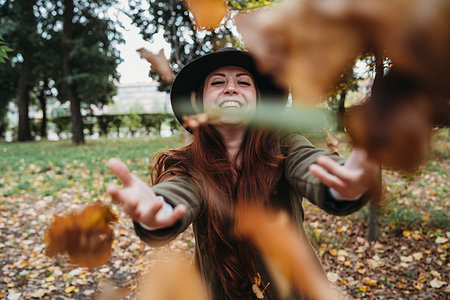 simsearch:649-08824082,k - Young woman with long red hair throwing autumn leaves in park Photographie de stock - Premium Libres de Droits, Code: 649-09257853