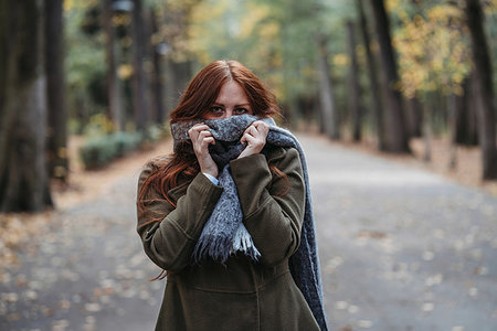 simsearch:649-08084940,k - Young woman with long red hair in autumn park covering mouth with scarf, portrait Foto de stock - Sin royalties Premium, Código: 649-09257864