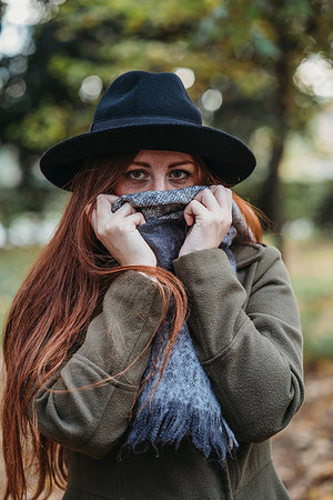 simsearch:649-08084940,k - Young woman with long red hair in autumn park covering mouth with scarf, portrait Foto de stock - Sin royalties Premium, Código: 649-09257865