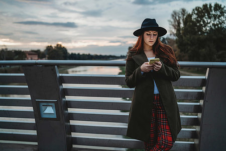 simsearch:649-09252022,k - Young woman with long red hair leaning on footbridge looking at smartphone at dusk, Florence, Tuscany, Italy Photographie de stock - Premium Libres de Droits, Code: 649-09257912