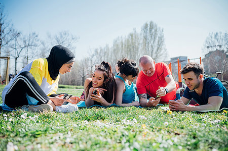 simsearch:614-08148721,k - Calisthenics class at outdoor gym, women and men lying on grass looking at smartphones Foto de stock - Sin royalties Premium, Código: 649-09257961