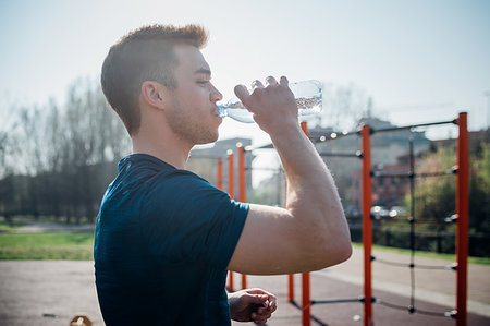 simsearch:649-09111293,k - Calisthenics at outdoor gym, young man drinking bottled water Fotografie stock - Premium Royalty-Free, Codice: 649-09257983