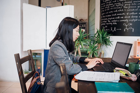 simsearch:649-09269104,k - Young businesswoman remote working on laptop at cafe table Stock Photo - Premium Royalty-Free, Code: 649-09258049